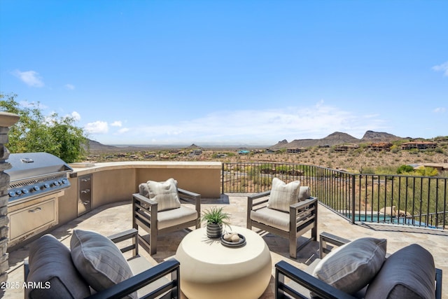 view of patio / terrace featuring an outdoor kitchen, a mountain view, area for grilling, and outdoor lounge area