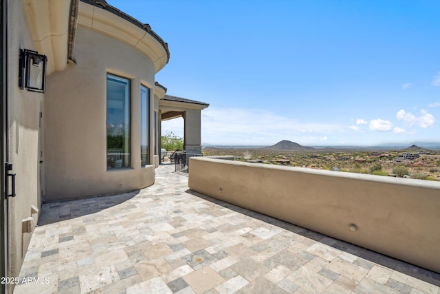 view of patio / terrace featuring a mountain view and a balcony