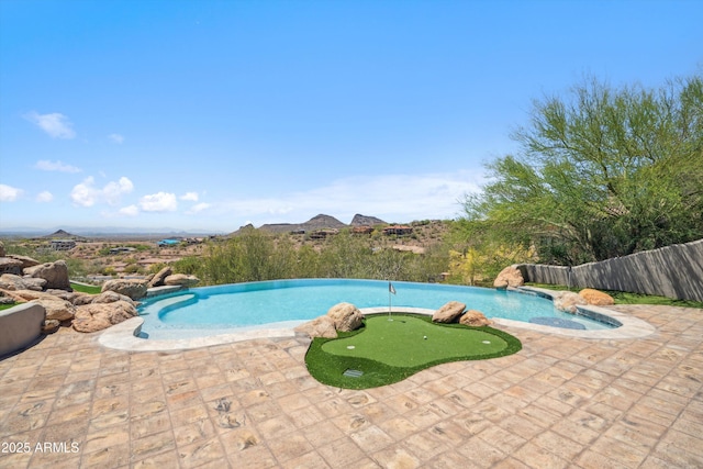 view of pool with fence, a patio area, and an infinity pool
