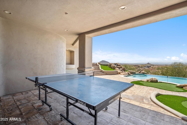view of patio featuring outdoor dining space, an outdoor pool, and stairway