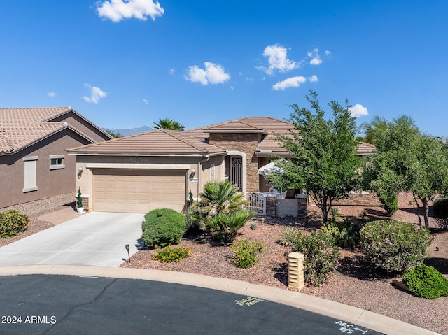 view of front of home with driveway, a tile roof, stucco siding, and a garage