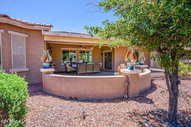 rear view of house featuring outdoor lounge area, ceiling fan, stucco siding, and a patio area