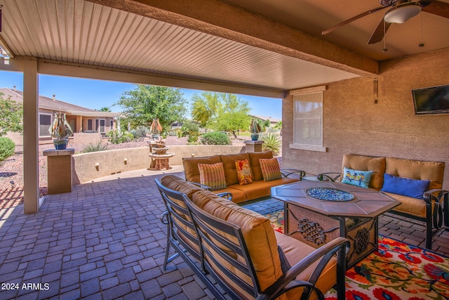 view of patio with ceiling fan and an outdoor living space with a fire pit