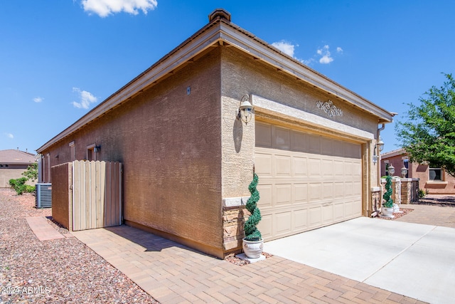 view of home's exterior with cooling unit and a garage