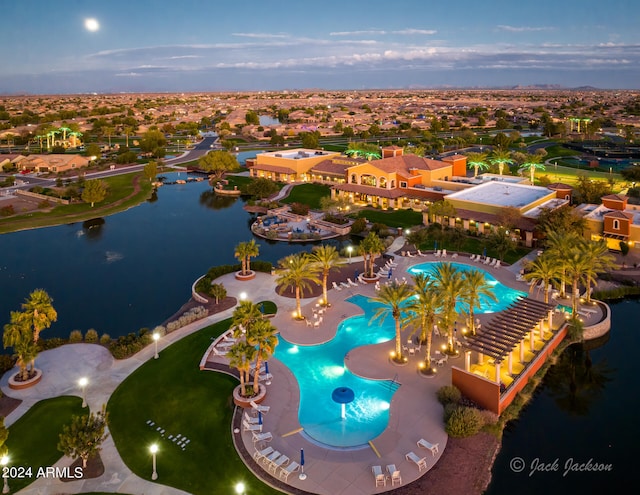 aerial view at dusk featuring a water view