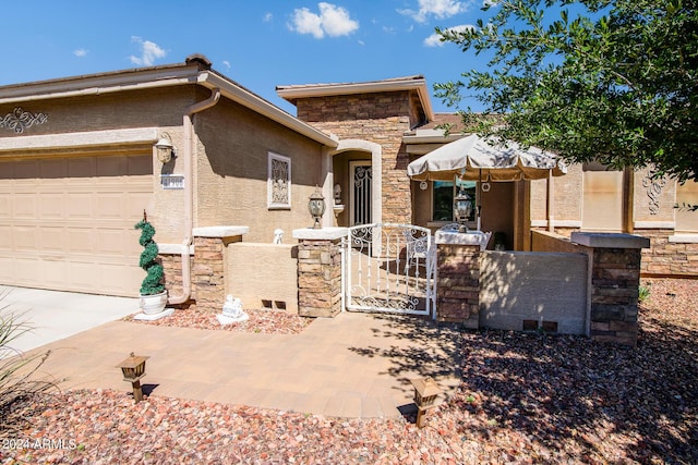 view of front of property with a garage, a gate, a fenced front yard, and stone siding