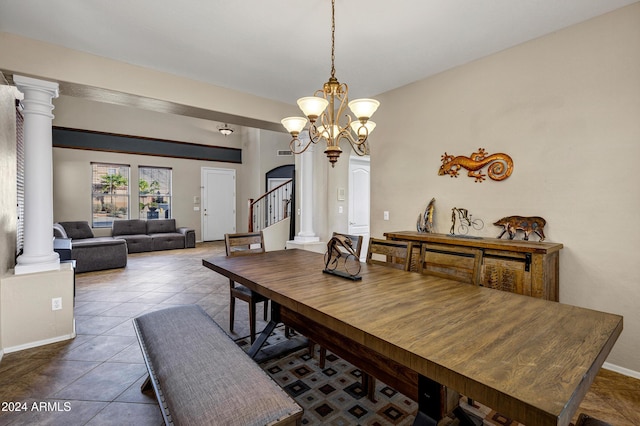 dining area featuring a chandelier, decorative columns, and tile patterned floors