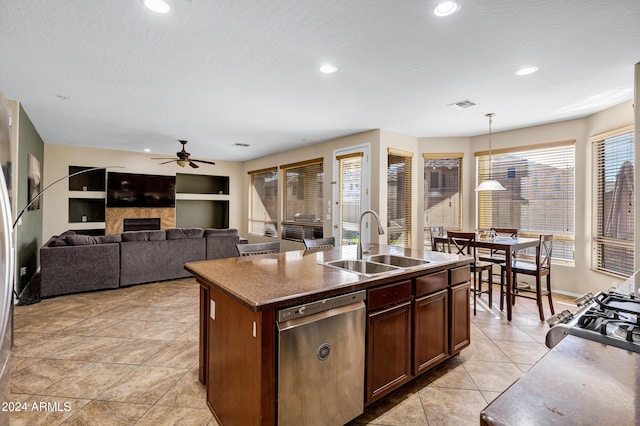 kitchen featuring dishwasher, a kitchen island with sink, sink, hanging light fixtures, and built in features