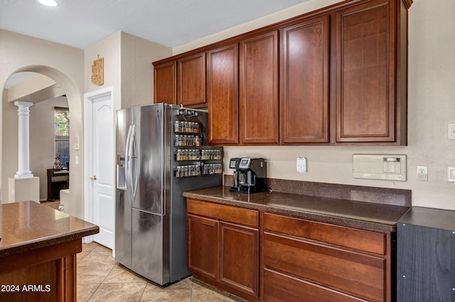 kitchen featuring stainless steel fridge, decorative columns, and light tile patterned floors