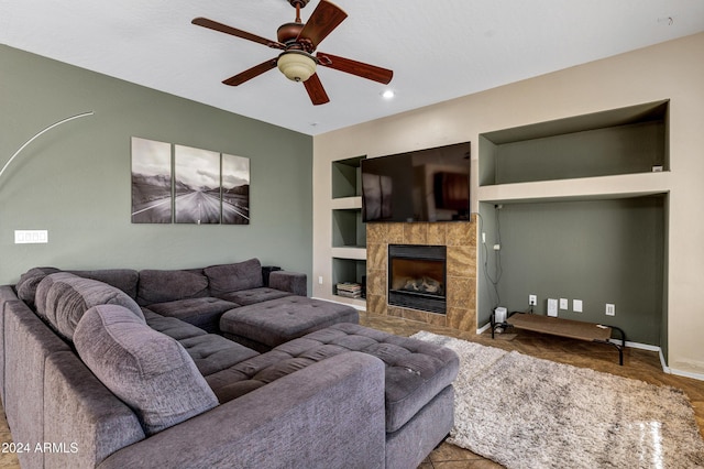 living room featuring a fireplace, built in shelves, and ceiling fan