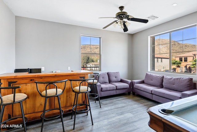 living room featuring ceiling fan, dark hardwood / wood-style flooring, and a healthy amount of sunlight