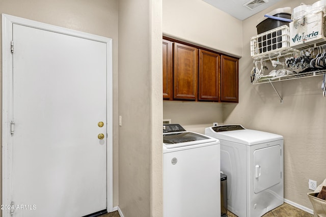 washroom with cabinets and washer and dryer