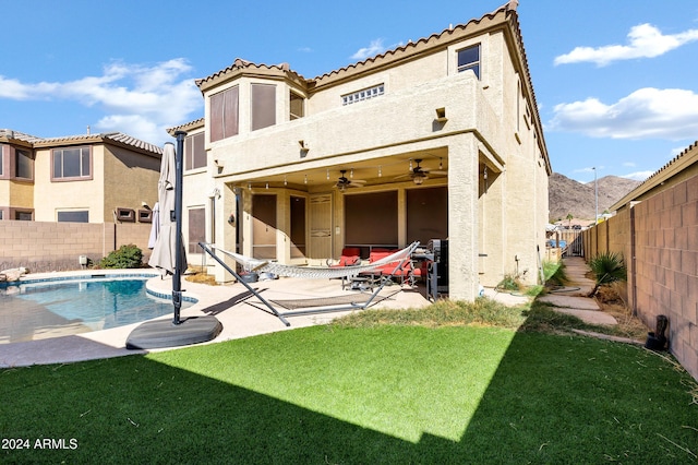 back of property with a fenced in pool, a patio area, ceiling fan, and a balcony