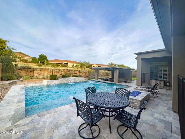 view of swimming pool with pool water feature and a patio area