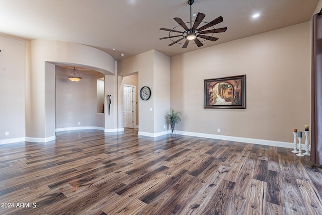 unfurnished living room with dark wood-type flooring and ceiling fan