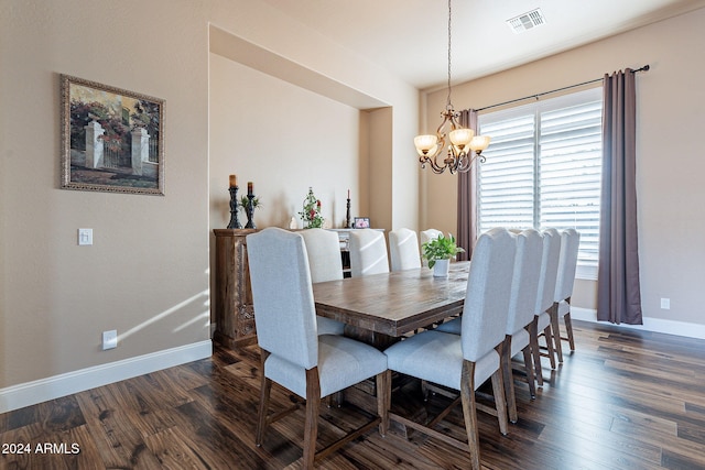 dining area with dark hardwood / wood-style floors and an inviting chandelier