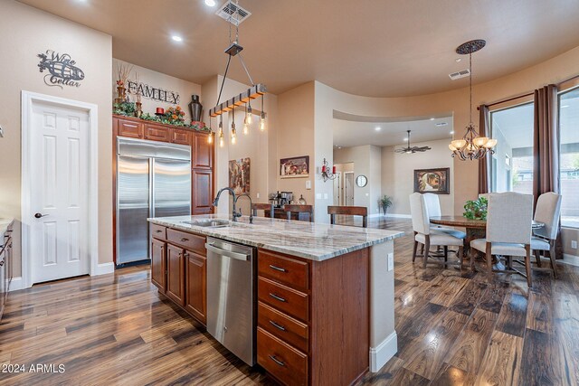 kitchen with dark hardwood / wood-style floors, hanging light fixtures, sink, and stainless steel appliances