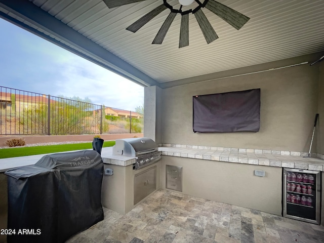 view of patio / terrace with ceiling fan, area for grilling, and a grill