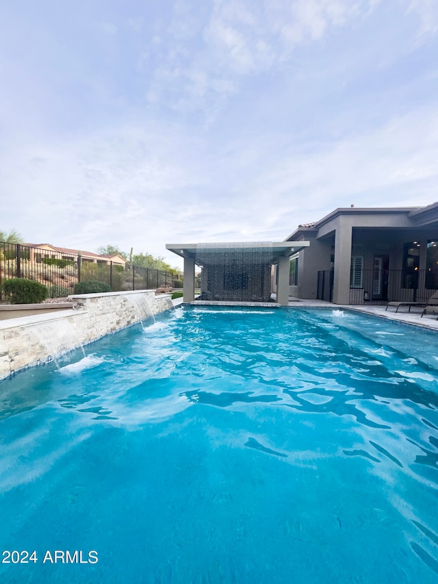 view of swimming pool with pool water feature