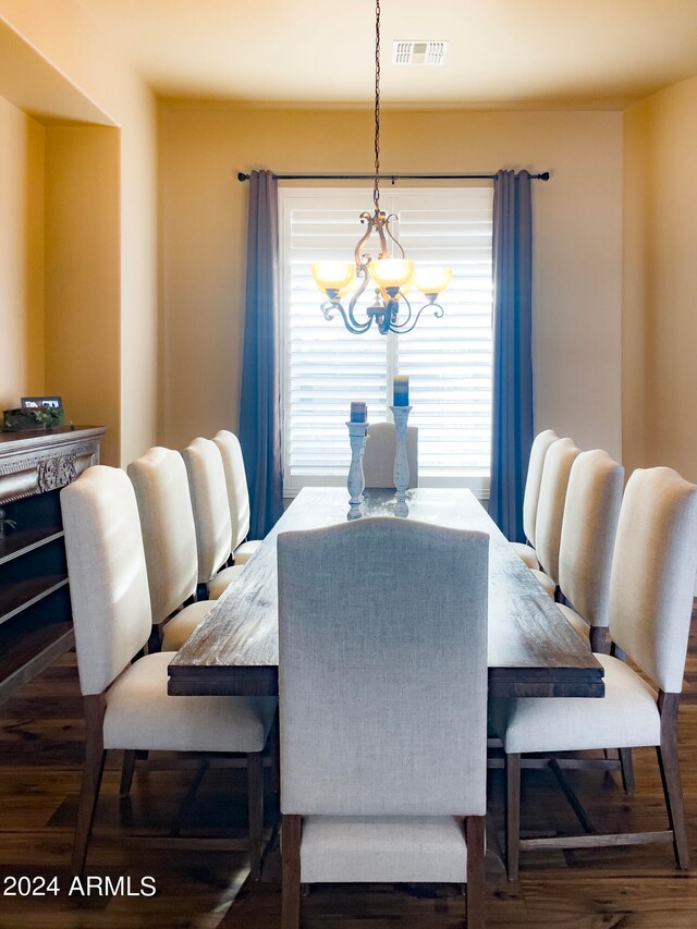 dining area featuring a chandelier and dark wood-type flooring