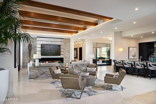 tiled living room with a large fireplace and beam ceiling