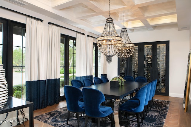 dining area featuring plenty of natural light, coffered ceiling, and an inviting chandelier