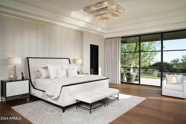 bedroom with dark hardwood / wood-style floors and an inviting chandelier