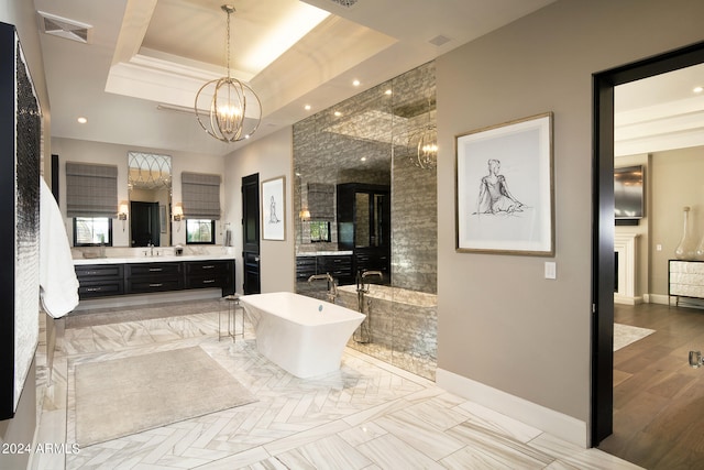 bathroom with vanity, a tray ceiling, hardwood / wood-style flooring, shower with separate bathtub, and a chandelier