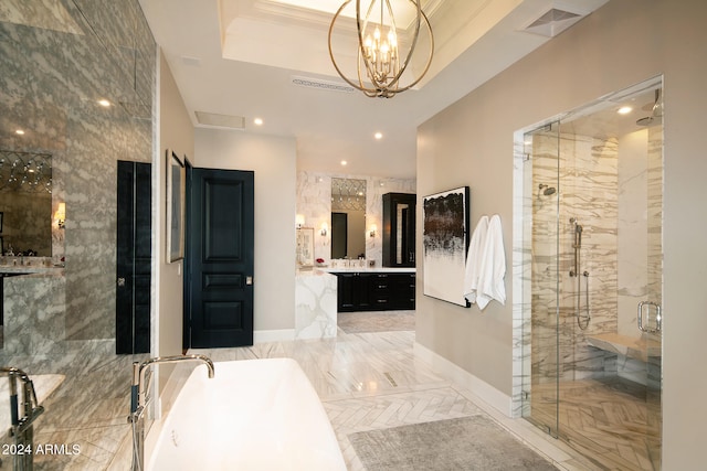 bathroom featuring tile walls, vanity, a tray ceiling, shower with separate bathtub, and an inviting chandelier