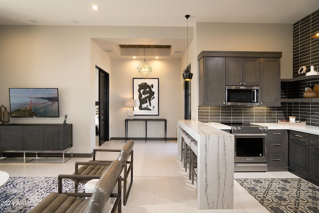 kitchen featuring dark brown cabinets, backsplash, stainless steel appliances, pendant lighting, and light tile floors