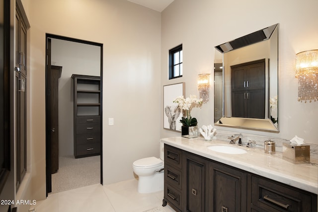 bathroom featuring toilet, tile flooring, and vanity