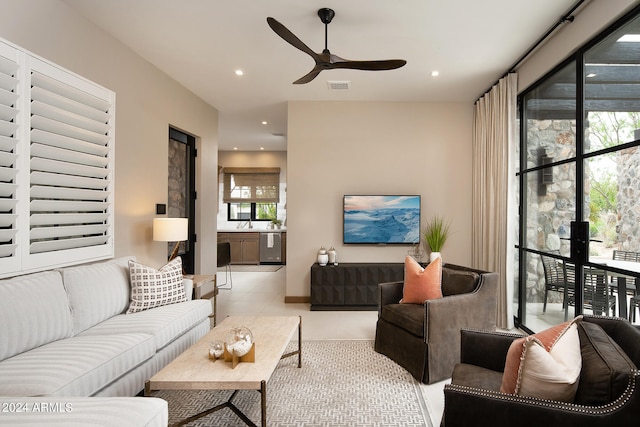 tiled living room featuring sink and ceiling fan