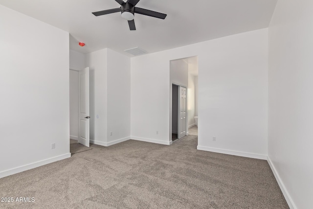 empty room with a ceiling fan, visible vents, light carpet, and baseboards