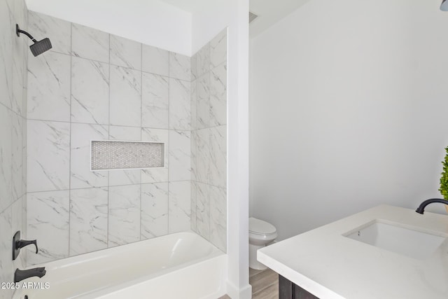 bathroom with toilet, vanity, wood finished floors, and bathing tub / shower combination