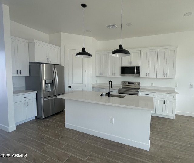 kitchen with light countertops, appliances with stainless steel finishes, a sink, and white cabinetry