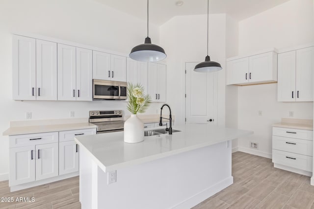 kitchen featuring stainless steel appliances, light countertops, and white cabinets