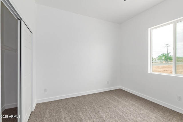 unfurnished bedroom featuring a closet, baseboards, and carpet flooring