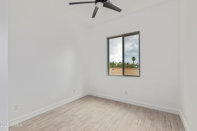 spare room with baseboards, a ceiling fan, and light wood-style floors