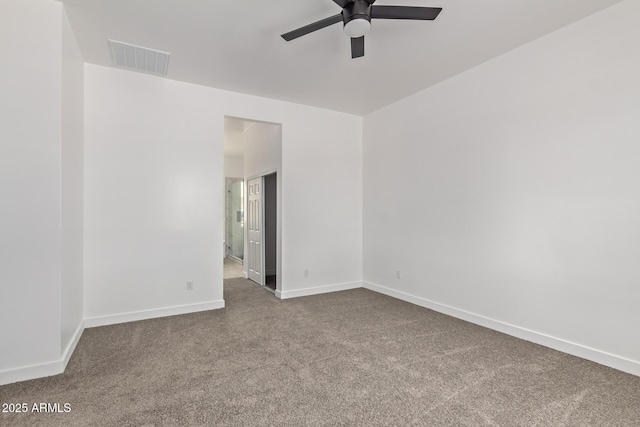 spare room with carpet floors, visible vents, baseboards, and a ceiling fan