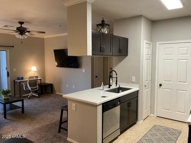5345 E Van Buren St Unit 370, Phoenix, AZ 85008 - kitchen featuring stainless steel dishwasher, a sink, light countertops, a ceiling fan, and a breakfast bar