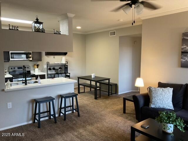 5345 E Van Buren St Unit 370, Phoenix, AZ 85008 - living room with dark carpet, ceiling fan, ornamental molding, and baseboards