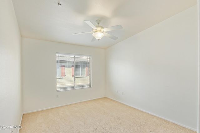 spare room featuring ceiling fan and light carpet