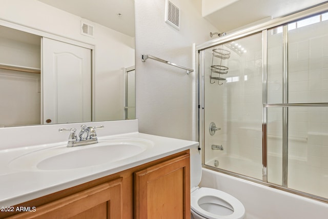 full bathroom featuring shower / bath combination with glass door, vanity, and toilet