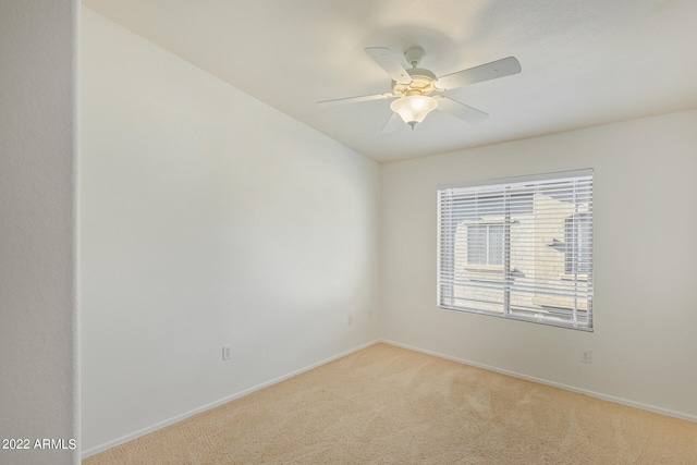 spare room with ceiling fan and light carpet