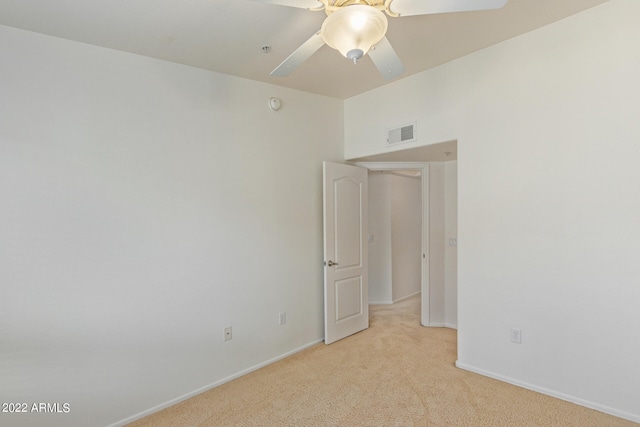 empty room featuring ceiling fan and light colored carpet