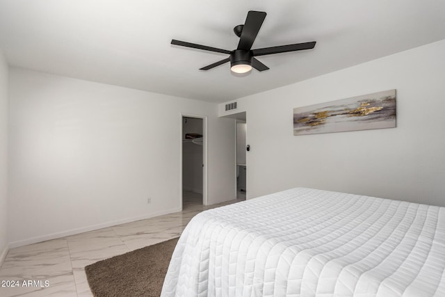 bedroom featuring a closet, a spacious closet, and ceiling fan