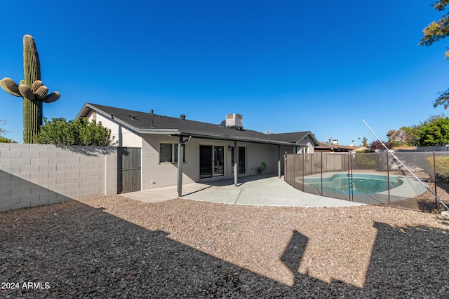 rear view of house with a fenced in pool, central AC, and a patio area