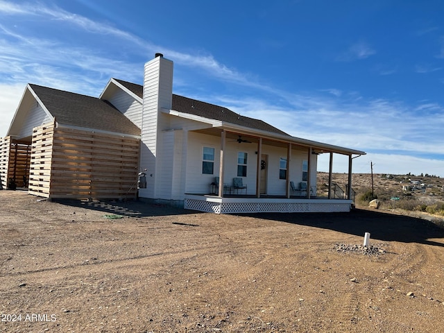 rear view of house featuring ceiling fan and covered porch