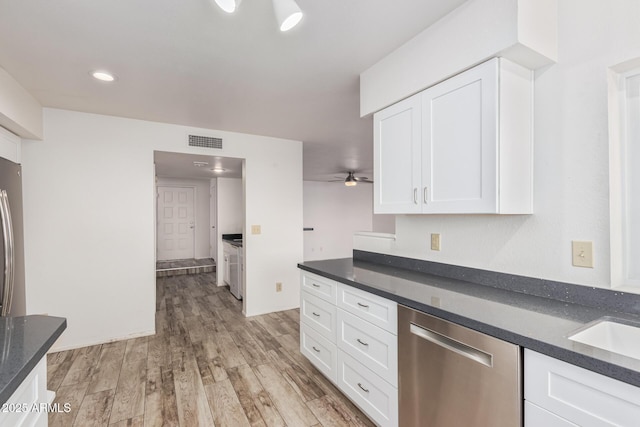 kitchen with visible vents, white cabinetry, appliances with stainless steel finishes, light wood-type flooring, and dark countertops