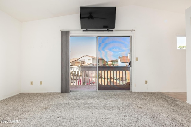 carpeted empty room with vaulted ceiling